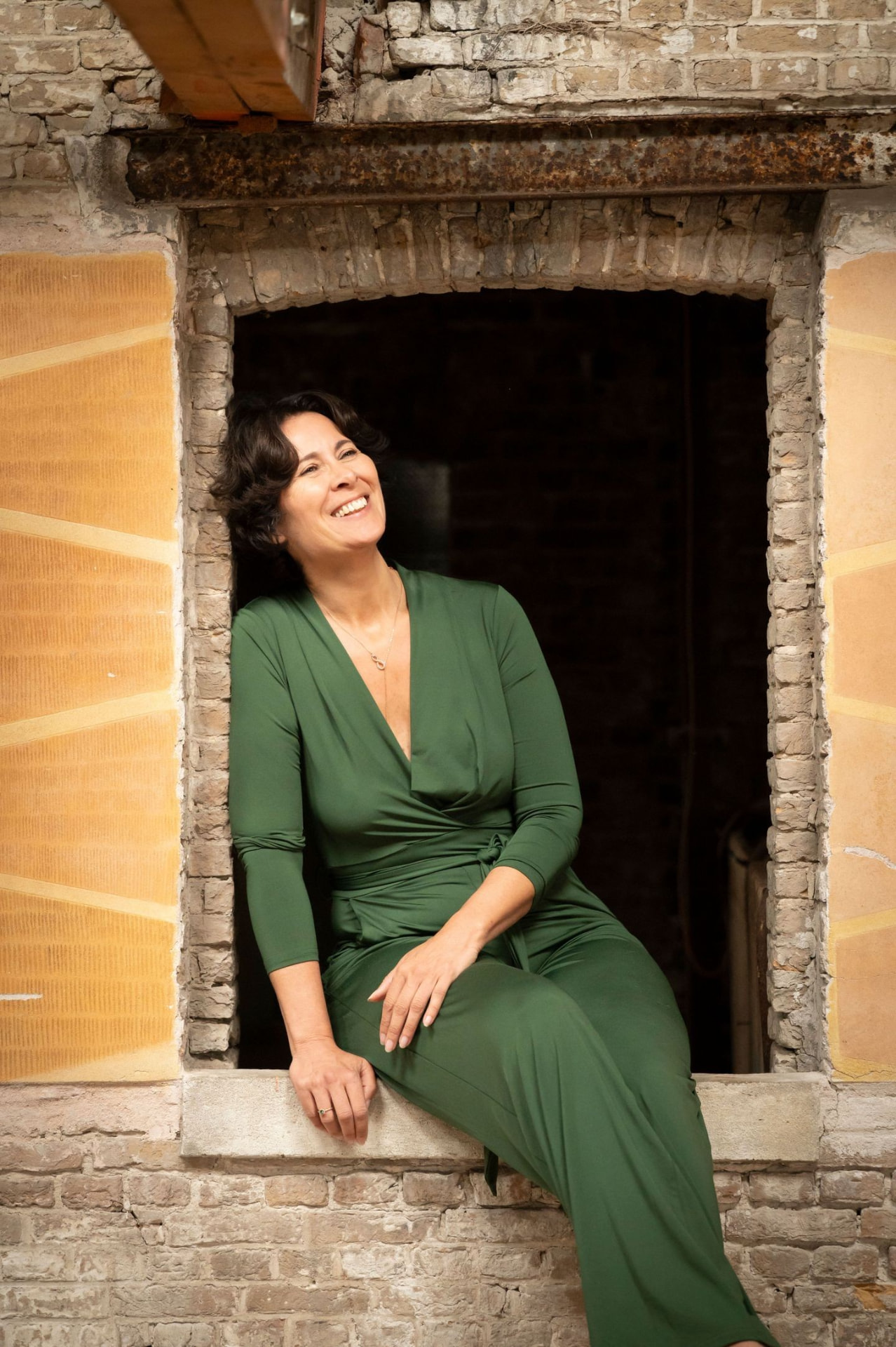 Francisca van Rhoon, zittend in een oud venster van een bakstenen muur
